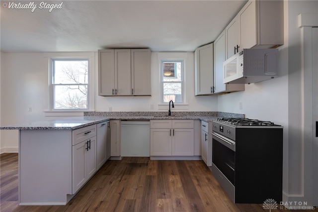 kitchen featuring light stone countertops, sink, dark hardwood / wood-style flooring, white appliances, and white cabinets