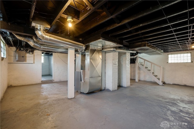 basement featuring electric panel and heating unit