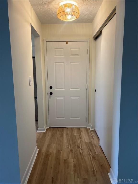 hallway featuring wood-type flooring and a textured ceiling