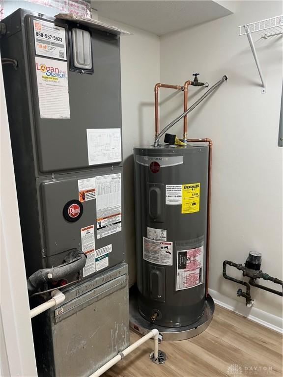 utility room with heating unit and electric water heater