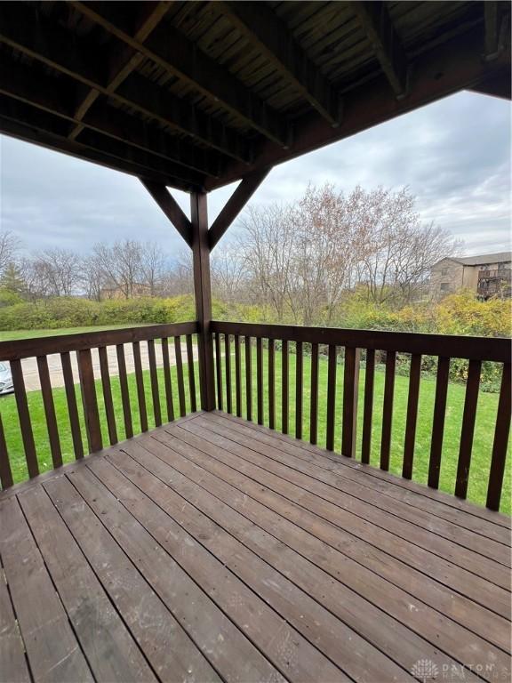 wooden deck featuring a lawn