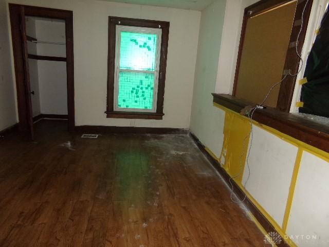 unfurnished bedroom featuring dark wood-style floors, visible vents, and baseboards