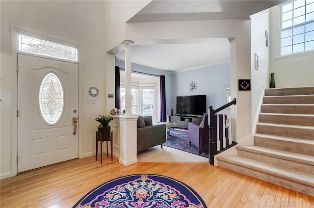 entryway with ornate columns, crown molding, and wood-type flooring