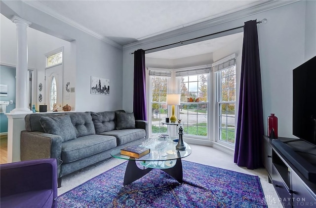 carpeted living room with crown molding and decorative columns