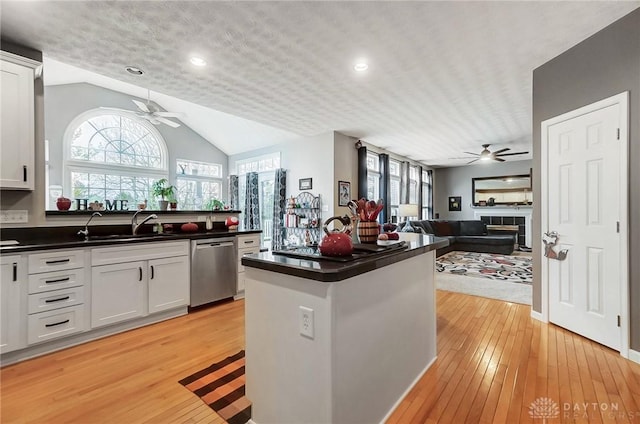 kitchen featuring sink, dishwasher, white cabinets, and light hardwood / wood-style flooring