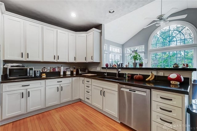 kitchen with lofted ceiling, sink, light hardwood / wood-style flooring, stainless steel dishwasher, and white cabinetry