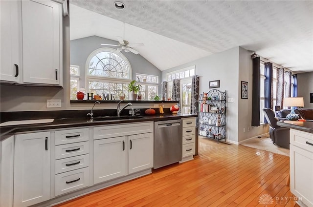 kitchen featuring ceiling fan, sink, dishwasher, light hardwood / wood-style flooring, and a textured ceiling