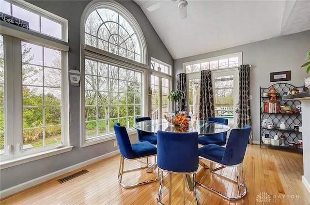 dining area with lofted ceiling, light hardwood / wood-style flooring, and a healthy amount of sunlight