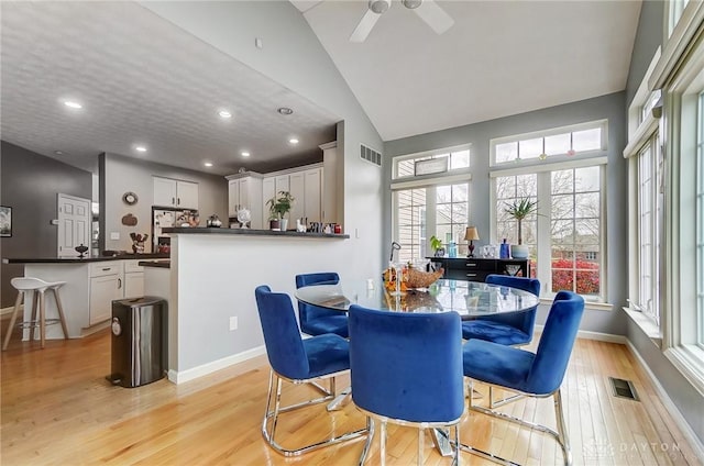 dining area with vaulted ceiling, light hardwood / wood-style flooring, and ceiling fan