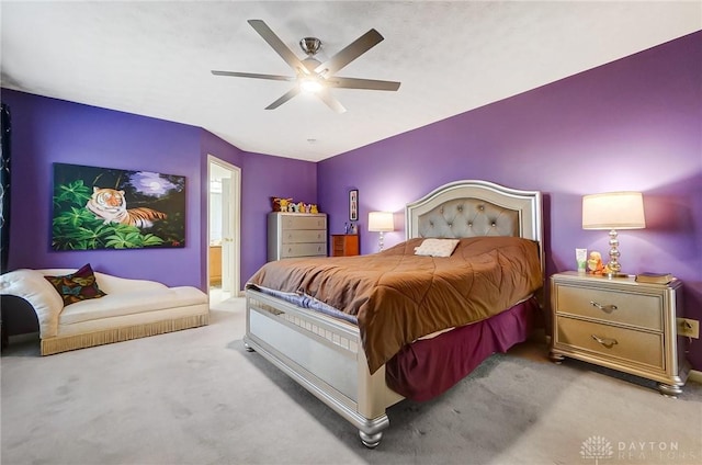 bedroom with connected bathroom, ceiling fan, and light colored carpet