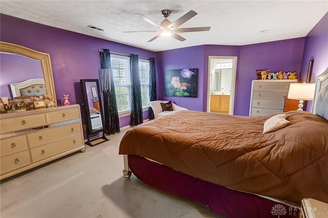 bedroom with connected bathroom, light colored carpet, and ceiling fan