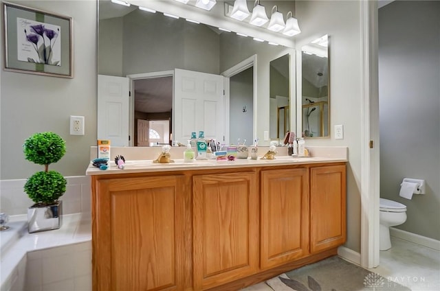 bathroom with vanity, a relaxing tiled tub, and toilet