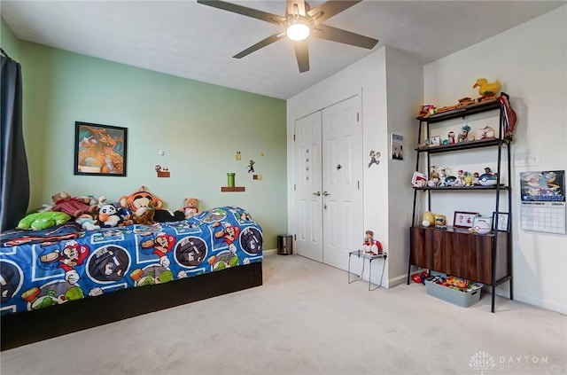 bedroom featuring ceiling fan, light carpet, and a closet