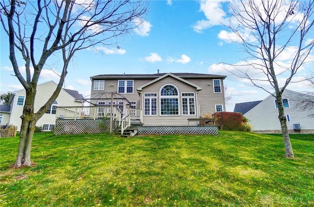 rear view of property with a lawn, a wooden deck, and central AC