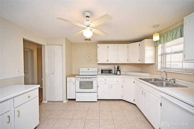 kitchen featuring white appliances, white cabinetry, light countertops, and a sink