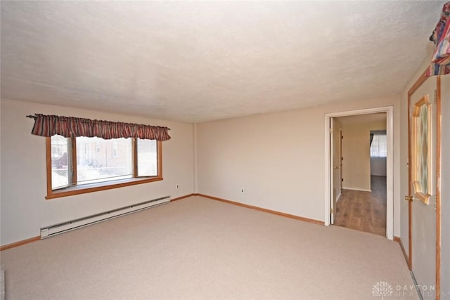 empty room featuring light carpet, a textured ceiling, a baseboard radiator, and baseboards