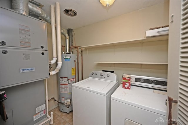 clothes washing area with laundry area, heating unit, separate washer and dryer, and gas water heater