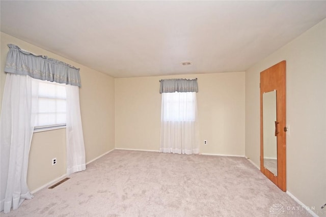 spare room featuring carpet floors and baseboards