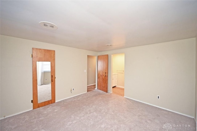 unfurnished bedroom with carpet floors, visible vents, and baseboards