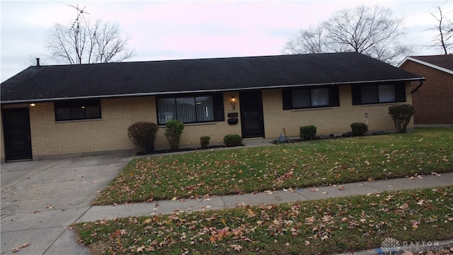 single story home featuring a lawn