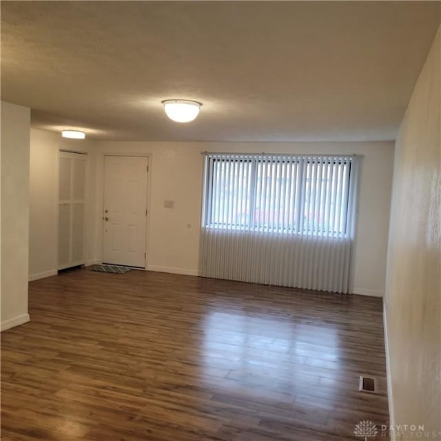 empty room with dark hardwood / wood-style floors