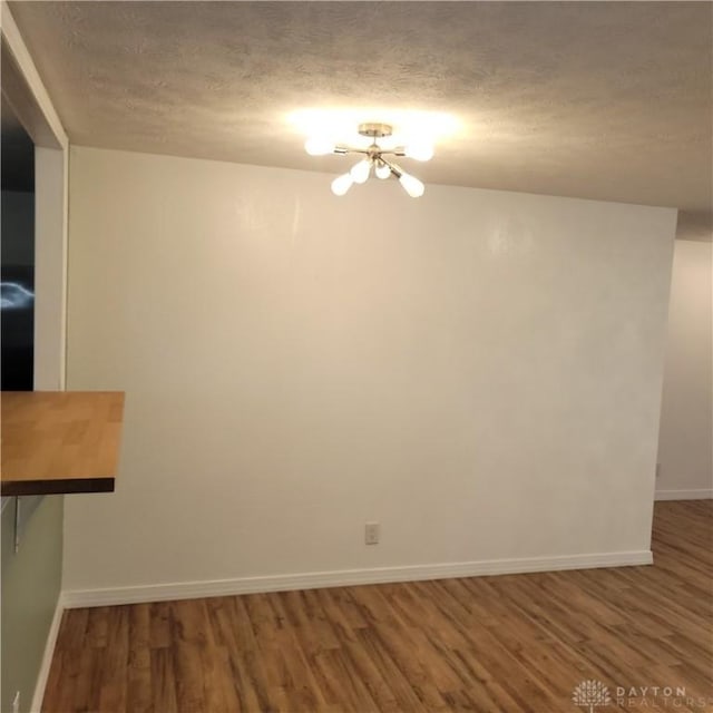 spare room with a textured ceiling and dark wood-type flooring