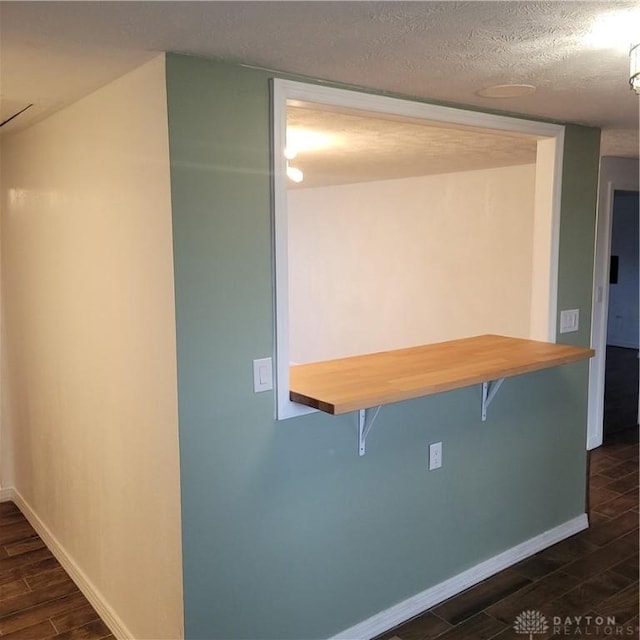 1246 Angiers Dr, Dayton, OH 45417 - kitchen featuring wood tiled floor, a breakfast bar area, baseboards, and a textured ceiling
