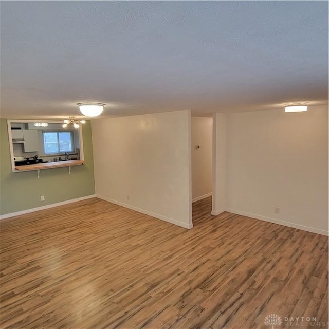 basement with wood-type flooring and a textured ceiling