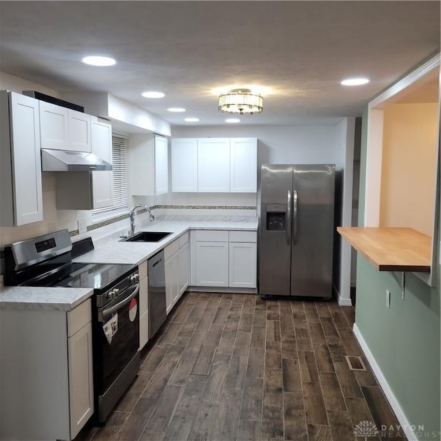 kitchen featuring stainless steel appliances, extractor fan, dark wood-type flooring, sink, and white cabinets