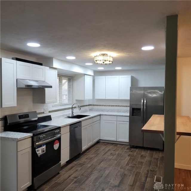 kitchen featuring dark hardwood / wood-style flooring, white cabinets, stainless steel appliances, and sink