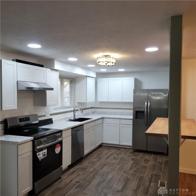1246 Angiers Dr, Dayton, OH 45417 - kitchen featuring dark wood-style flooring, appliances with stainless steel finishes, white cabinets, a sink, and under cabinet range hood