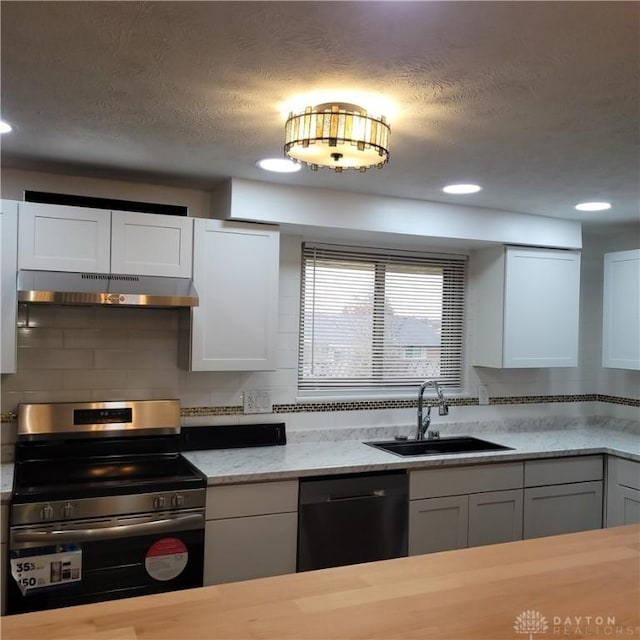 kitchen featuring dishwasher, stainless steel stove, white cabinets, and sink