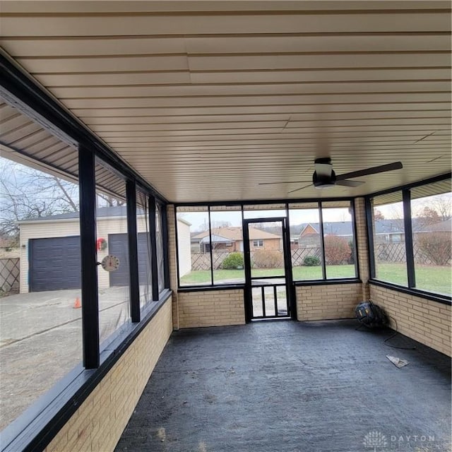 unfurnished sunroom featuring ceiling fan