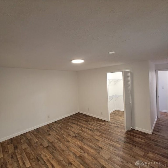 unfurnished room with dark hardwood / wood-style flooring