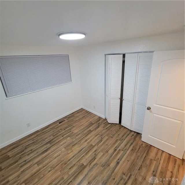 unfurnished bedroom featuring a closet and wood-type flooring