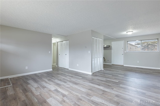 empty room featuring light hardwood / wood-style flooring and a textured ceiling