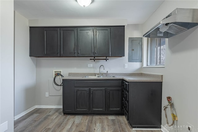 kitchen featuring sink, electric panel, light hardwood / wood-style floors, and range hood