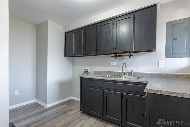 kitchen featuring sink, electric panel, and light wood-type flooring