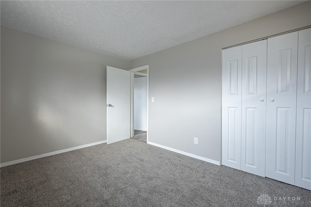 unfurnished bedroom featuring a closet, carpet, and a textured ceiling