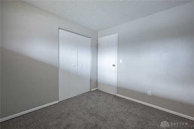 unfurnished bedroom with a closet, a textured ceiling, and carpet flooring