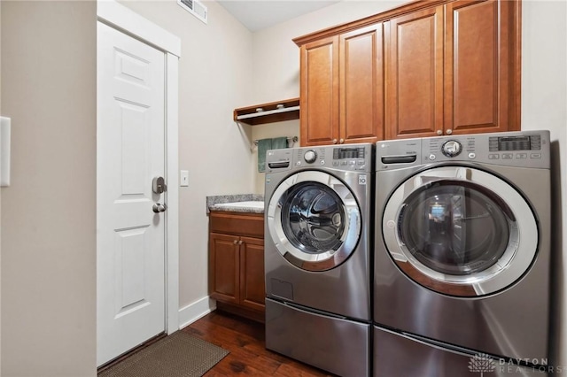 laundry area featuring cabinets, dark hardwood / wood-style flooring, and separate washer and dryer