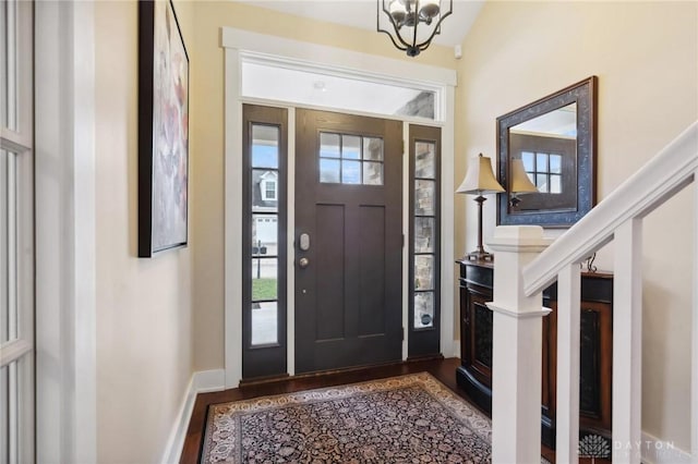 foyer entrance with wood-type flooring and a chandelier