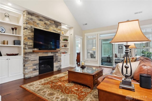 living room featuring dark hardwood / wood-style flooring, built in features, a fireplace, and a wealth of natural light