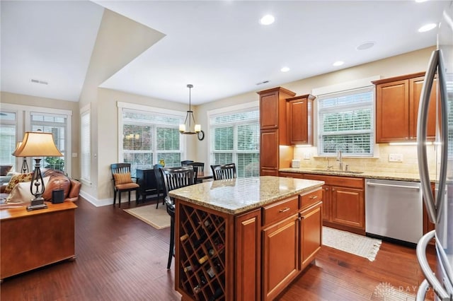 kitchen with a center island, lofted ceiling, sink, a healthy amount of sunlight, and stainless steel appliances