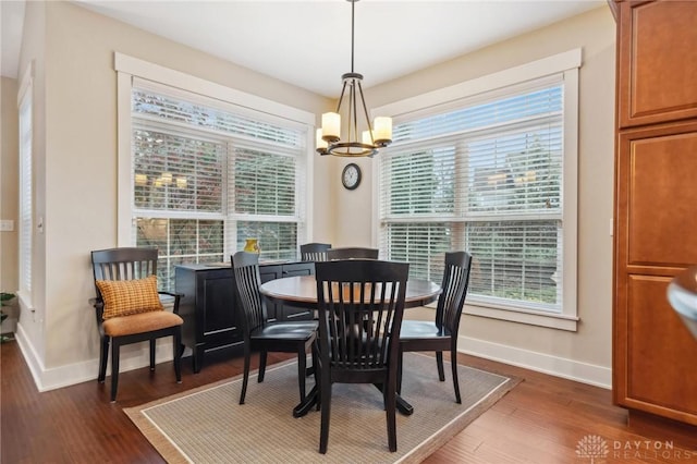 dining space featuring a chandelier, dark hardwood / wood-style floors, and a healthy amount of sunlight