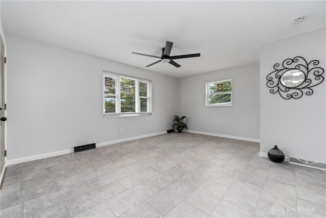 unfurnished room featuring ceiling fan and plenty of natural light