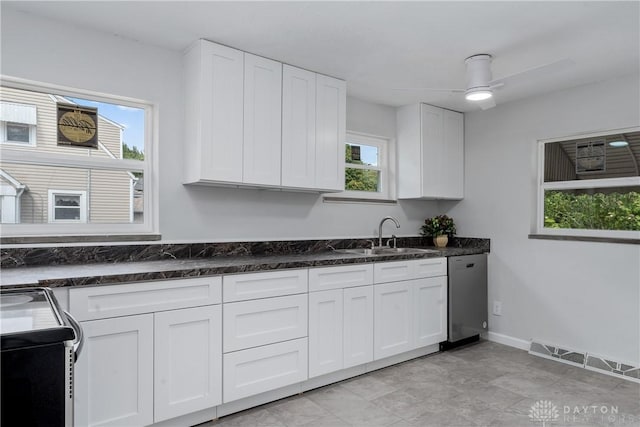 kitchen featuring ceiling fan, white cabinetry, sink, and range