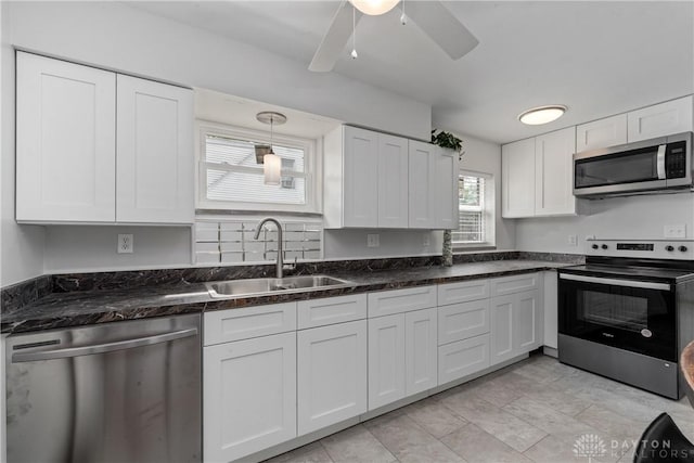 kitchen featuring white cabinets, appliances with stainless steel finishes, a healthy amount of sunlight, and sink