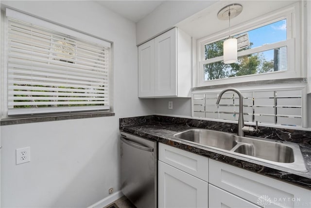 kitchen featuring dark stone counters, sink, stainless steel dishwasher, decorative light fixtures, and white cabinetry