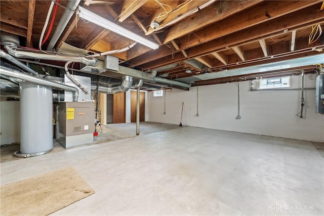 basement with heating unit, electric panel, and gas water heater